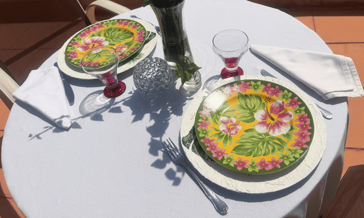 Composición de mesa con vajilla estampada y elementos decorativos en tonos neutros