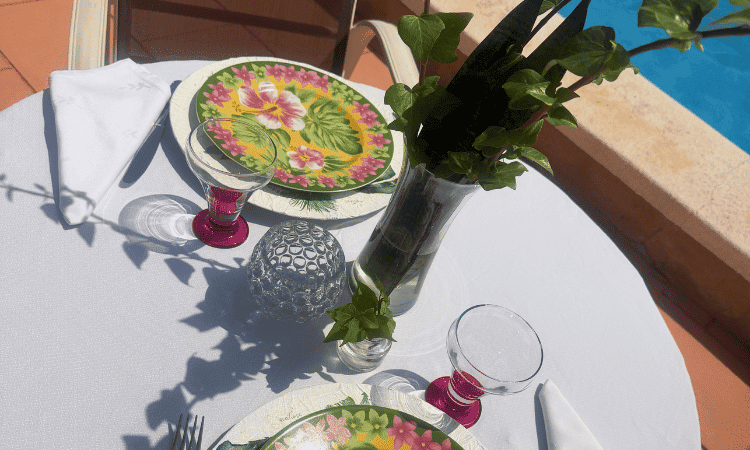 Mesa de exterior con vajilla de flores y decoración equilibrada inspirada en el verano