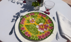 Mesa elegante con vajilla estampada floral y bajoplato blanco en un comedor de exterior