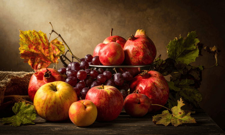 Centro de mesa de otoño con granadas, frutas y hojas