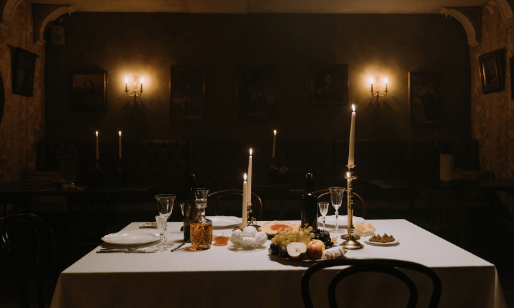 Mesa de cena de misterio iluminada con velas y candelabros